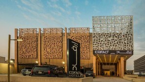 The exterior of the Erfad Hotel with a modern architectural design, featuring intricate wooden lattice patterns and illuminated signage. - Erfad Hotel-Riyadh (Riyadh)