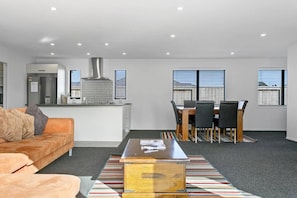 A modern apartment with a kitchen, dining area, and living room.