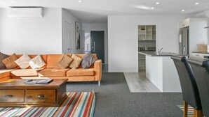 Un salon moderne avec un canapé, une table basse et un tapis à rayures.