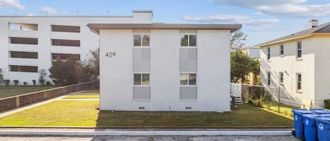 Un edificio de una planta con el número 409, rodeado de césped y un sendero pavimentado.
