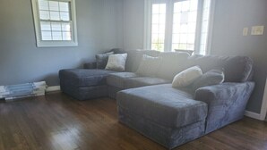 A living room with a sectional sofa, a wooden floor, and a window. - Comfortable Cozy Walk to Camc Hospital (Charleston)