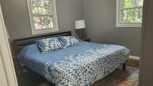 A bedroom with a bed, two windows, a nightstand, and a lamp. - Comfortable Cozy Walk to Camc Hospital (Charleston)