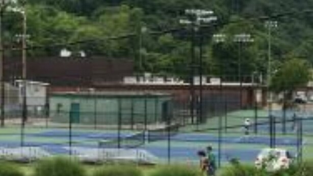 A tennis court with a net, surrounded by a fence. - Comfortable Cozy Walk to Camc Hospital (Charleston)