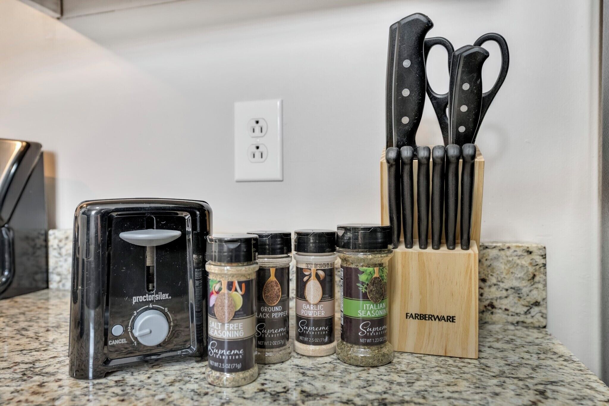 A kitchen counter with a salt shaker, a toaster, and a knife block.