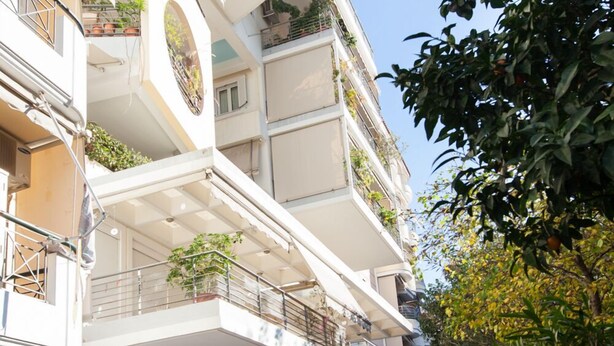 Un edificio de varios pisos con balcones, una escalera y un cartel que indica un centro de negocios.