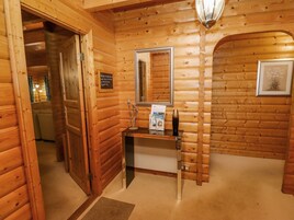 Un interior de madera con un mostrador de recepción, un espejo enmarcado y un letrero de bienvenida.
