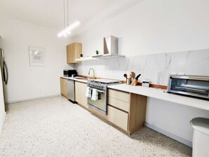 Une cuisine moderne équipée d’un four encastré, d’un four à micro-ondes et d’appareils électroménagers en acier inoxydable.