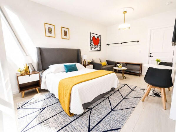 Une chambre d’hôtel moderne avec un grand lit, un canapé, une petite table et une chaise.