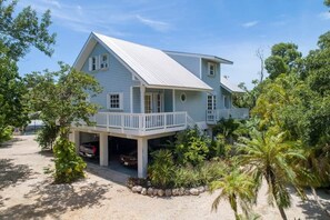 Stunning two-story house with a spacious balcony and lush garden surroundings.