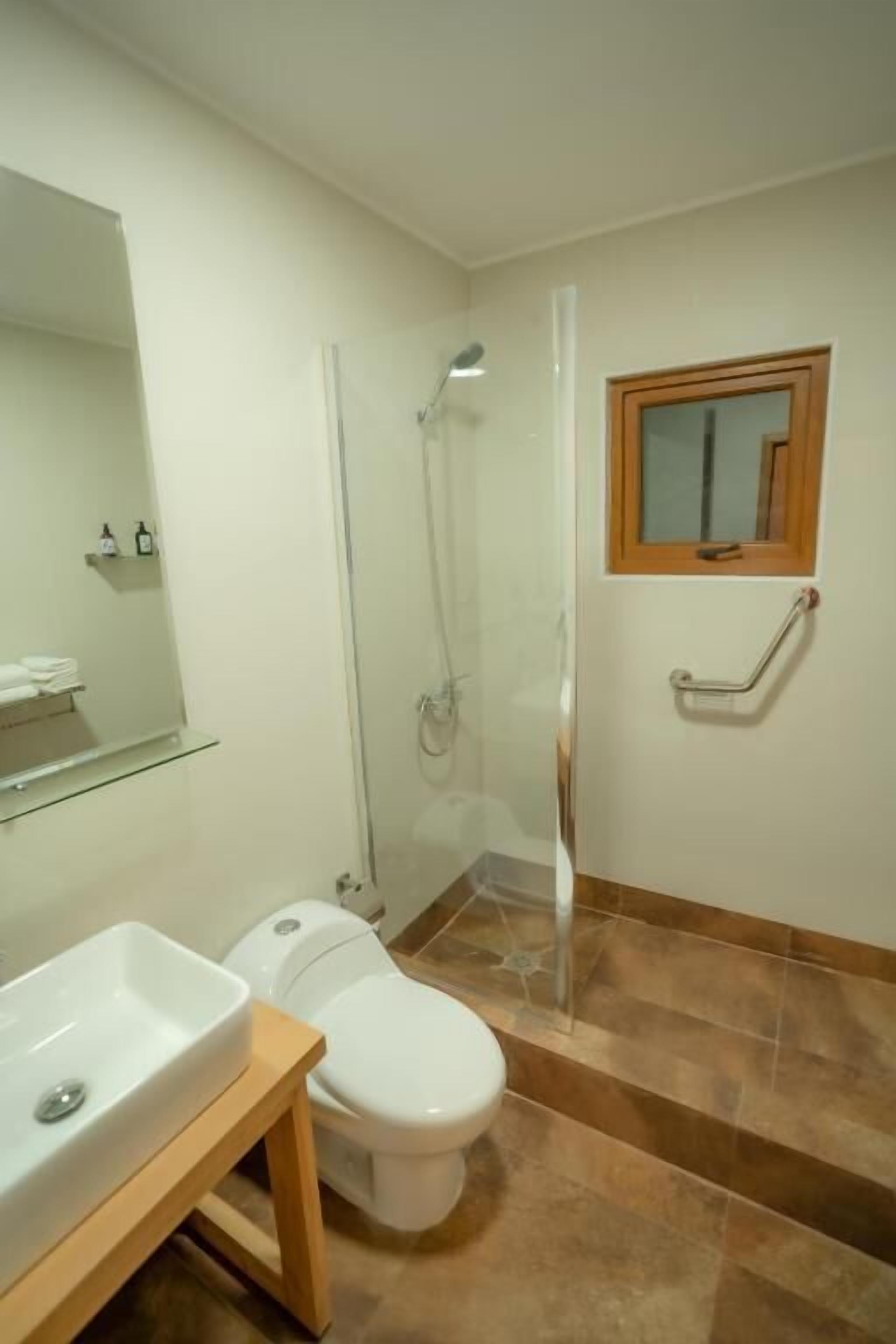 A bathroom with a shower, toilet, and sink.