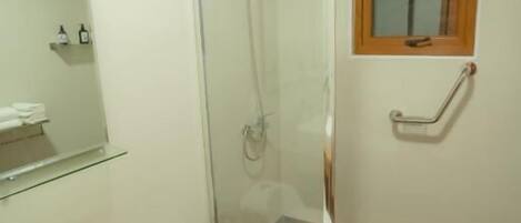 A bathroom with a shower, toilet, and sink.