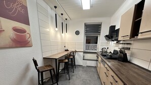 Una cocina moderna con una encimera larga, taburetes de bar y un cuadro con motivos de café.