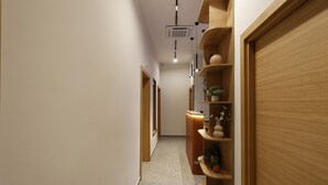 A hallway with wooden shelving units, a door, and a ceiling light fixture. - Hop Inn Rooms & Suites Belgrade (Belgrade)