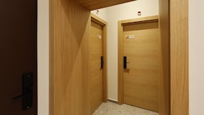 A hallway with two wooden doors labeled 01 and 02. - Hop Inn Rooms & Suites Belgrade (Belgrade)