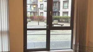 A modern apartment with a large sliding glass door leading to a balcony.