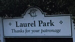 A sign for Laurel Park with a decorative emblem and the text "Thanks for your patronage."
