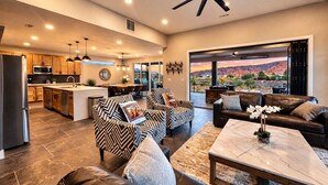 A spacious living area with a modern kitchen, a dining area, and a large window offering a scenic view.