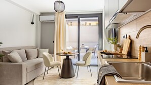 Cocina moderna con comedor, que incluye un sofá, sillas, una mesa redonda y una lámpara colgante.