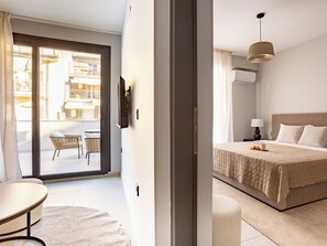Una habitación de hotel moderna con cama, escritorio y balcón con una silla.