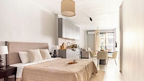 Una habitación de hotel moderna con una cama grande, un escritorio y una kitchenette.