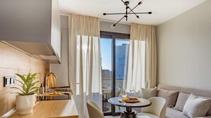 Una cocina moderna con encimera de madera, una planta en maceta y una zona de comedor con una mesa redonda y sillas.