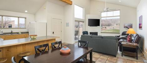 A spacious living area with a dining table, sofa, and TV.