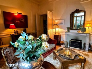Ein Wohnzimmer mit Sofa, Couchtisch, Kamin und einem großen Spiegel.