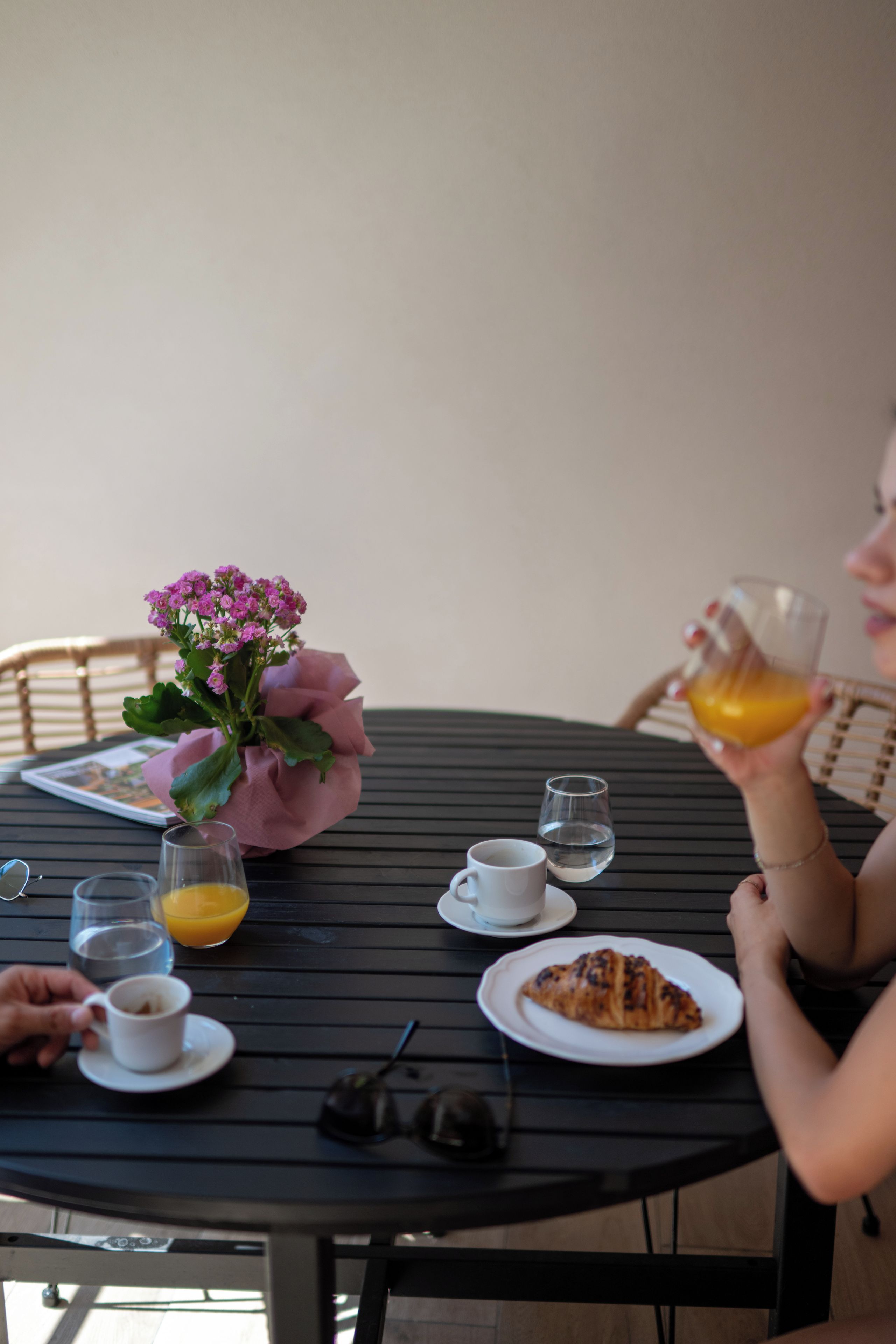Ein Tisch mit einem Teller Essen, einem Glas Orangensaft, einer Tasse Kaffee und einem kleinen Glas Wasser.