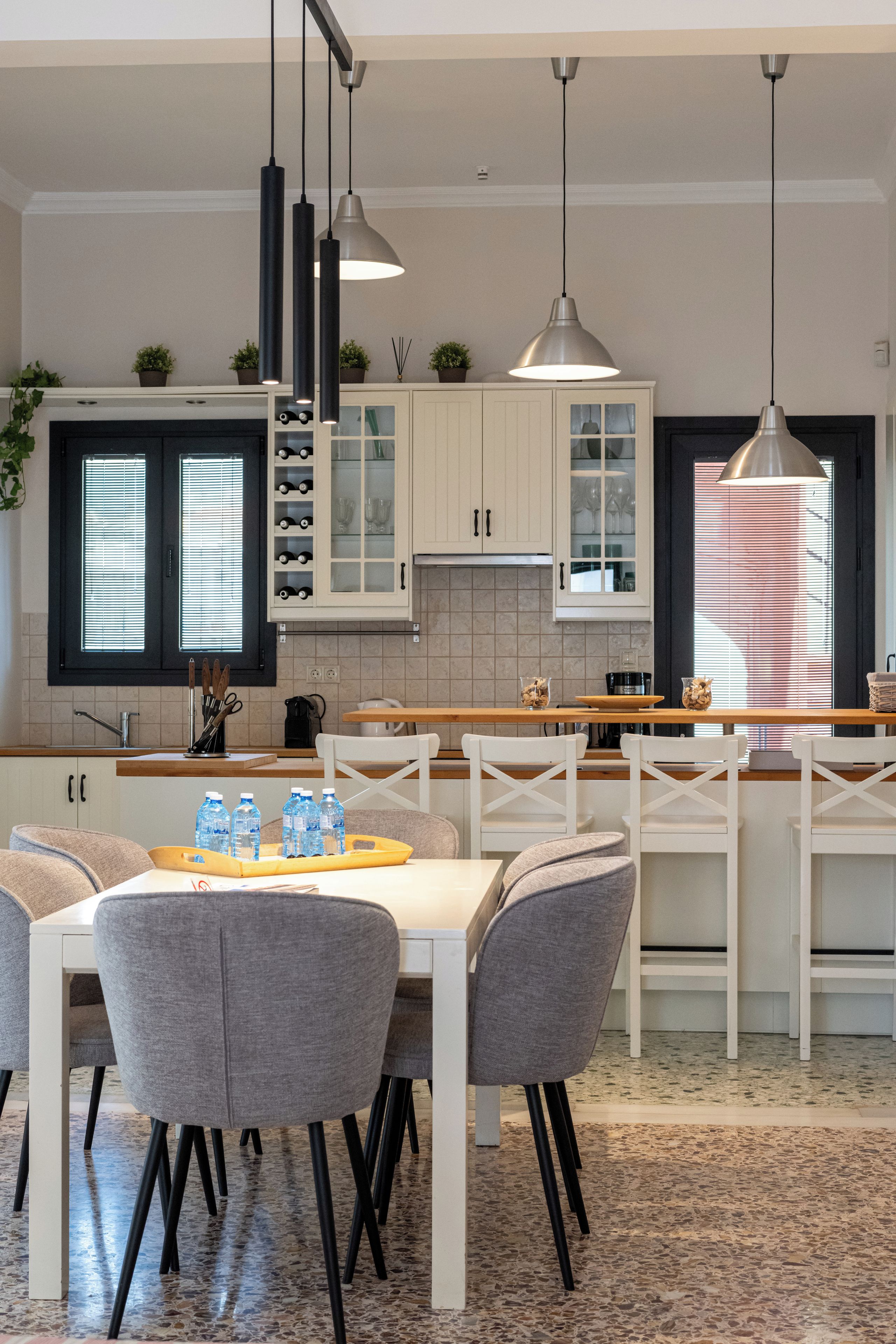 A modern kitchen with white cabinets, a central island, and pendant lighting.