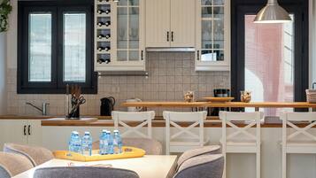 A modern kitchen with white cabinets, a central island, and pendant lighting.