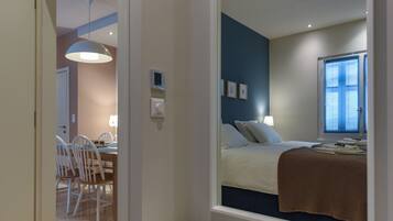 Ein Schlafzimmer mit Bett, Fenster und Blick nach draußen.