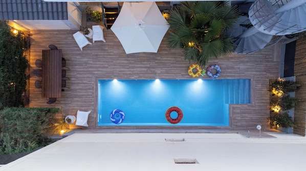 A rooftop pool with a wooden deck, lounge chairs, and umbrellas. - The Mansion - Kalamata Mediterranean Suites & Villas (Kalamata)