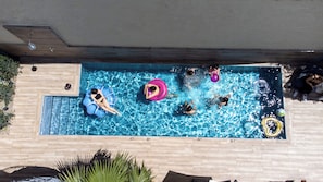 A rectangular swimming pool with a wooden deck surrounding it. - The Mansion - Kalamata Mediterranean Suites & Villas (Kalamata)