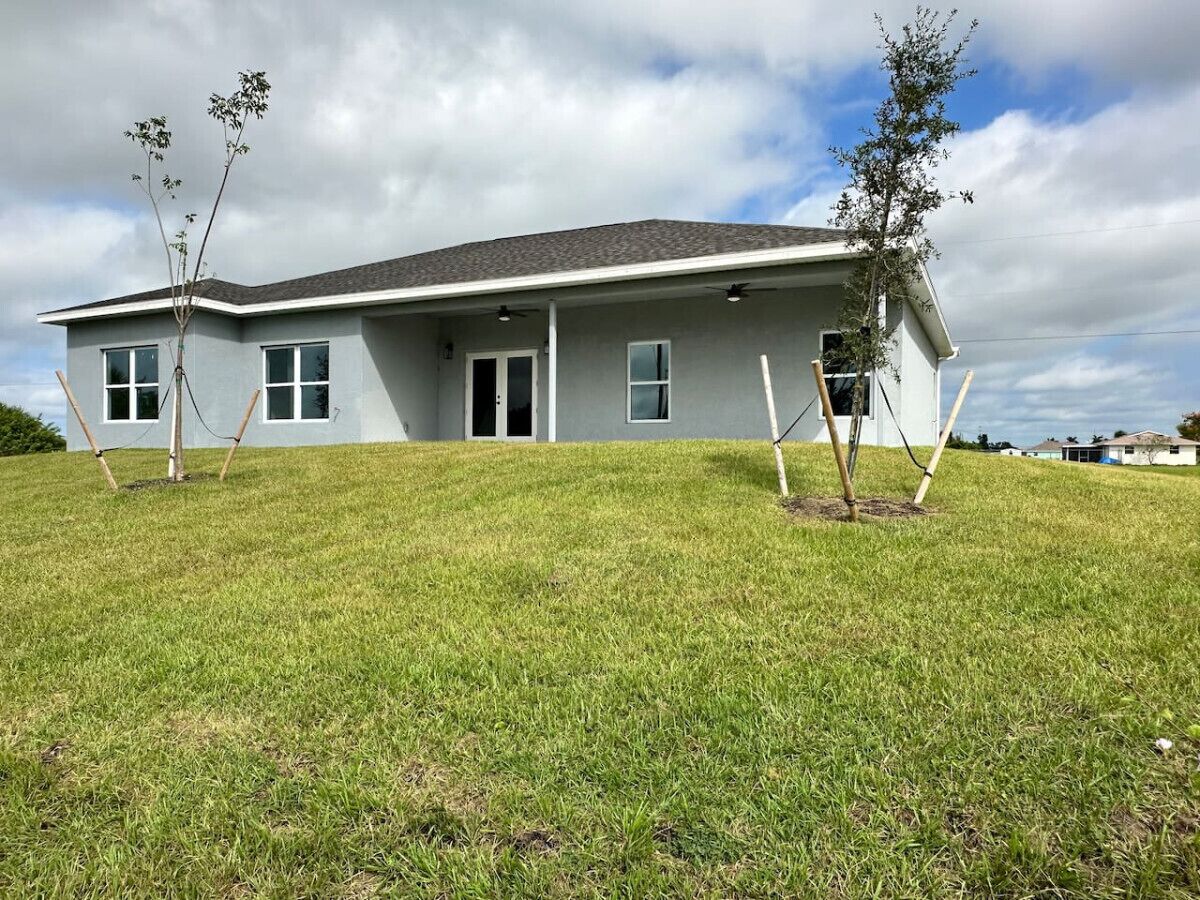 A modern two-story house with a flat roof and a covered porch.