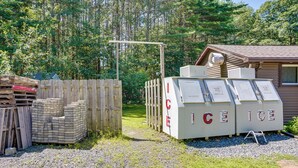 Varastoalue, jossa on puupaletteja, puinen aita ja kylmäkoneet, joissa on merkintä ”JÄÄHDYTYSLAITE”.