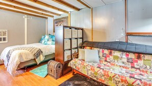 Une chambre avec deux lits, un plafond en bois et une armoire intégrée.