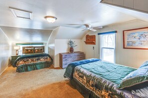 A bedroom with two beds, a ceiling fan, a dresser, a window with a view, and a painting on the wall. - Comanche County Home Near Hunting & Fishing! (Protection)