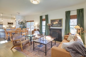 A spacious living room with a fireplace, dining area, and kitchen in the background. - Charming Appomattox Home: Half-mi to Main Street! (Appomattox)
