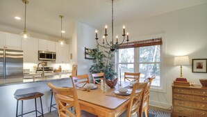 A spacious kitchen with a central island, wooden chairs, and a chandelier. - Charming Appomattox Home: Half-mi to Main Street! (Appomattox)