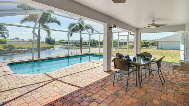 Un espacio al aire libre techado con piscina, mobiliario de patio y ventiladores de techo.