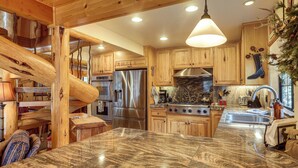 Une cuisine spacieuse dotée de meubles en bois, d’appareils électroménagers en acier inoxydable et d’un plan de travail en granit.