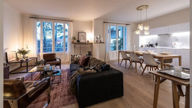A modern living room with a sofa, coffee table, and dining area with chairs and a table. - Luxurious apartment in the heart of Annecy (Annecy)