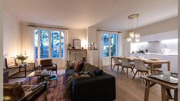 Un salon moderne comprenant un canapé, une table basse et un coin repas avec des chaises et une table.