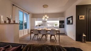 A modern kitchen with a dining area, large windows, and a chandelier. - Luxurious apartment in the heart of Annecy (Annecy)