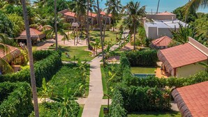A resort with a pool, palm trees, and a view of the ocean. - Monan Boutique Hotel  (Porto de Pedras)