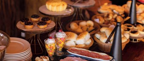 A buffet with various food items including pastries, meats, and desserts.