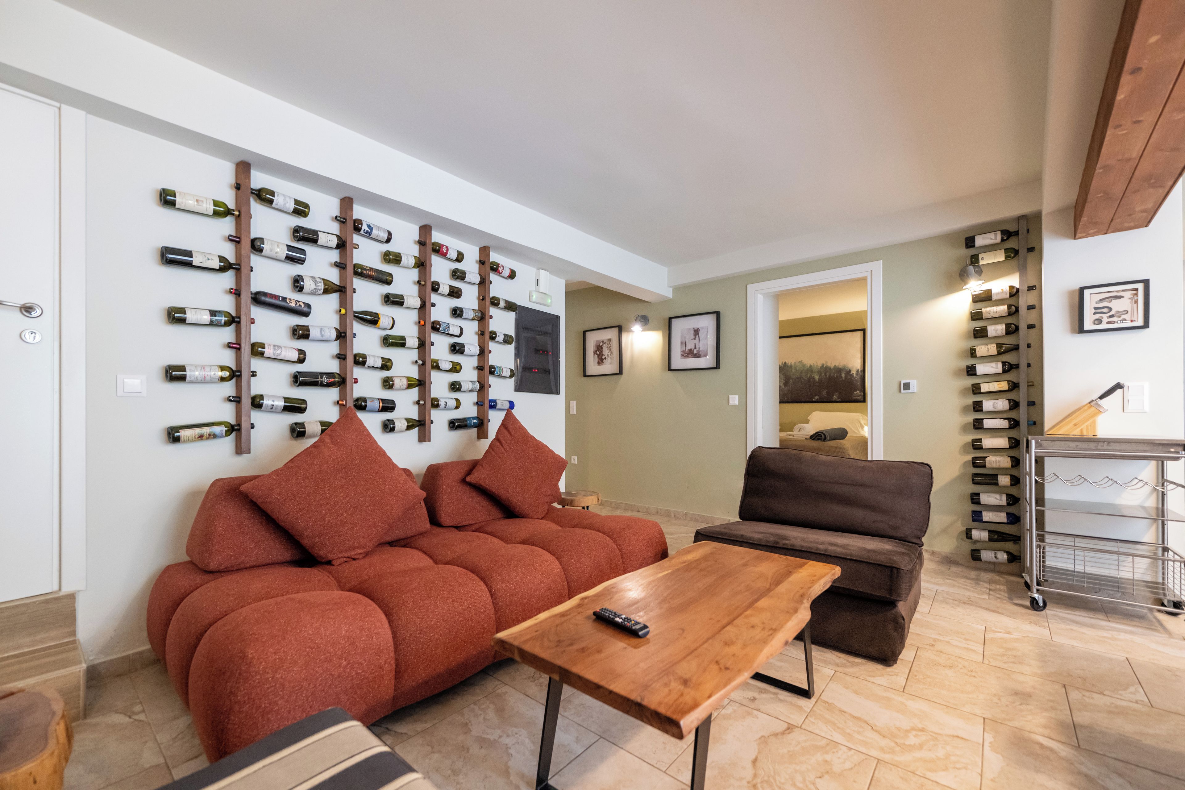 Ein Wohnzimmer mit einer Couch, einem Couchtisch und einem Weinschrank an der Wand.