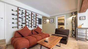 Ein Wohnzimmer mit einer Couch, einem Couchtisch und einem Weinschrank an der Wand.