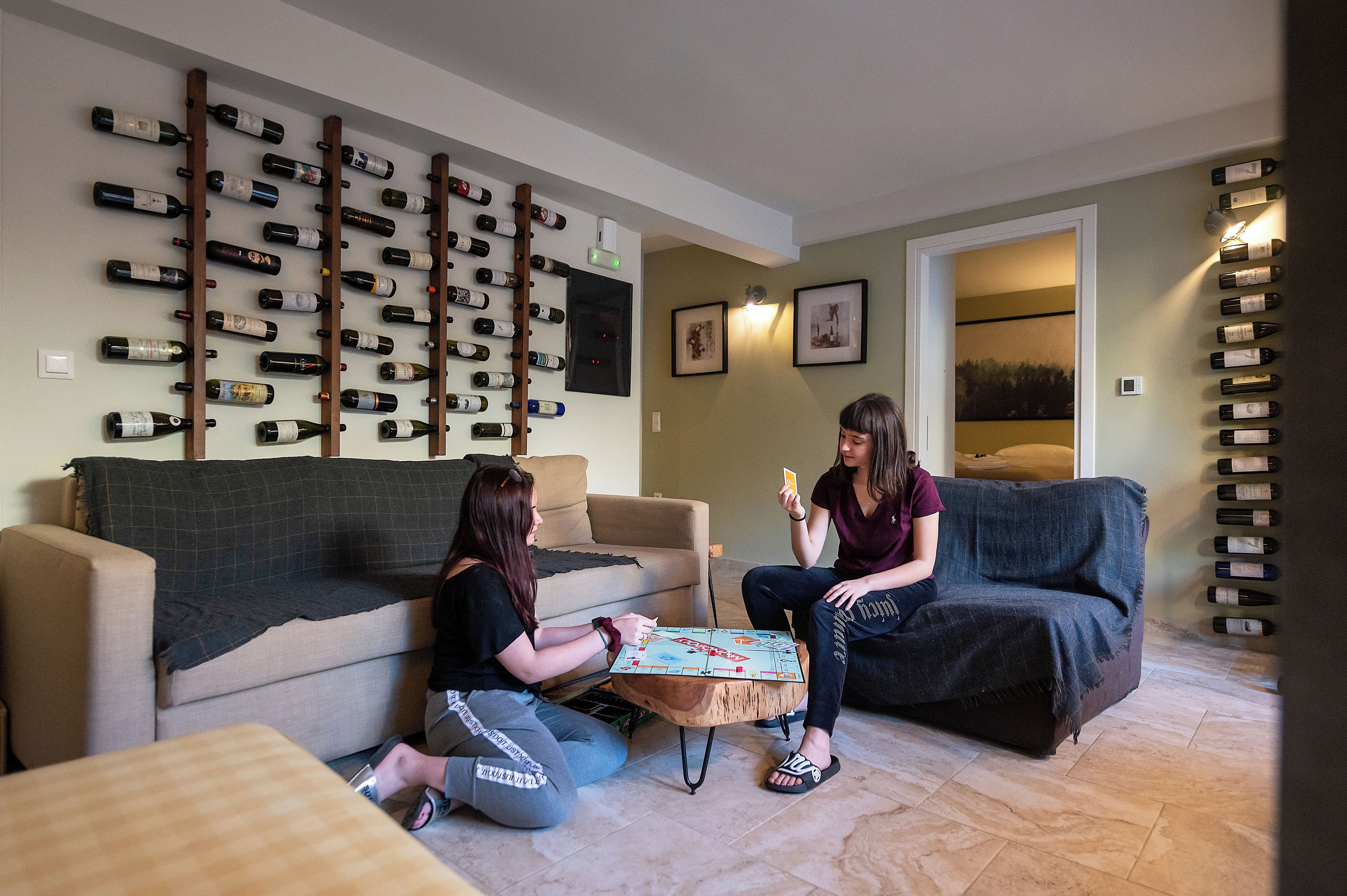 A living room with a sofa, a coffee table, and a wall-mounted wine rack.