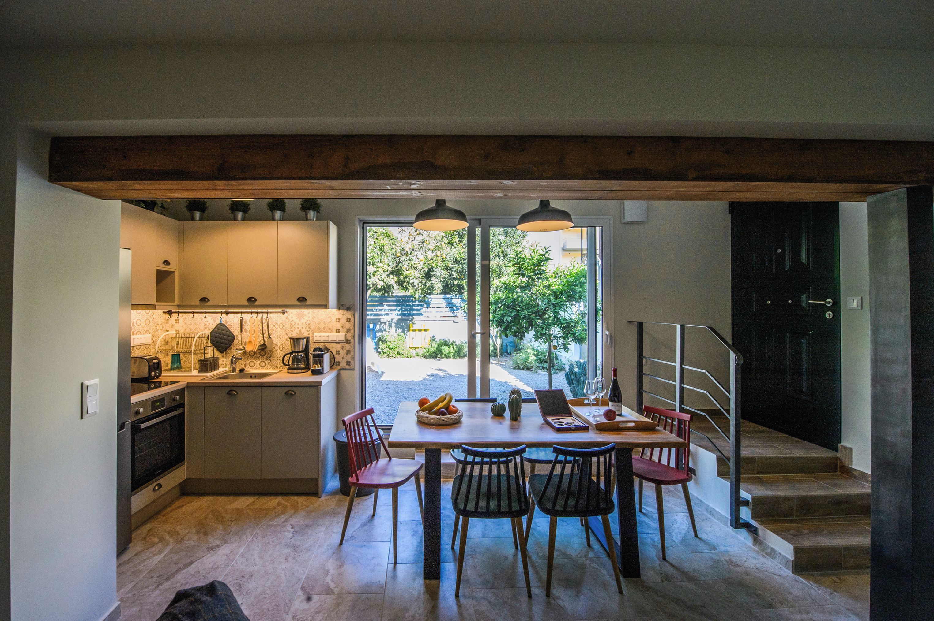 A kitchen with a dining area, a staircase, and a view of the outdoors.